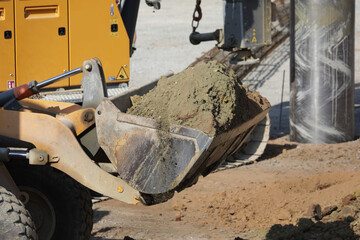 bagger mit erde in seiner schaufel auf einer baustelle