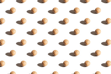 Walnuts on a white background. A pattern of walnuts on a white background. Hard shadows