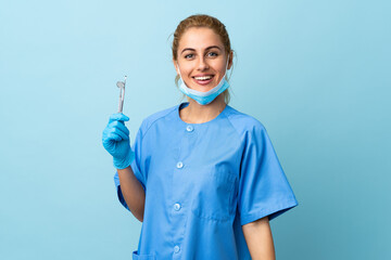 Young woman dentist holding tools over isolated blue background applauding