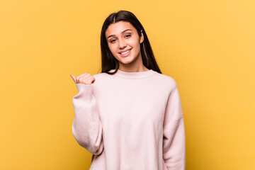 Young Indian woman isolated on yellow background shocked pointing with index fingers to a copy space.