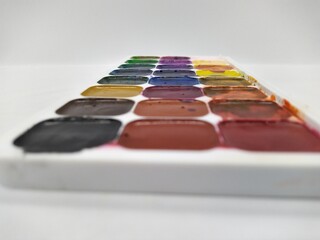 palette of used watercolor paints on white background