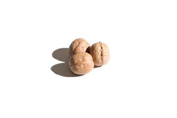 Three walnuts on a white background. Hard shadows. Isolated