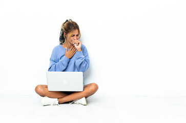 Young blonde Uruguayan girl with the laptop isolated on white background is suffering with cough and feeling bad