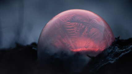 Frozen soap bubble with beautiful light and color on a wooden structure