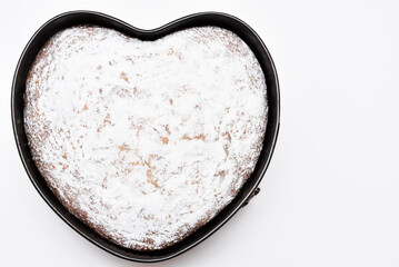 heart shaped cake in springform pan, freshly baked with love, top view on a white background