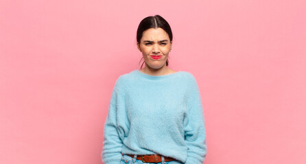 young pretty woman looking goofy and funny with a silly cross-eyed expression, joking and fooling...
