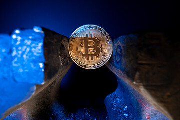 Bitcoin mounted in a steel vise isolated with black background. Keeping Bitcoin safe in crypto...