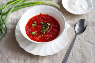 Traditional ukrainian vegetarian beet red soup - borscht with sour cream on the table. Top view.