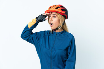 Young blonde Uruguayan cyclist woman isolated on background doing surprise gesture while looking to the side
