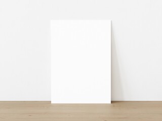 Blank vertically oriented rectangular poster standing on wooden floor leaning on white wall. 3D Illustration