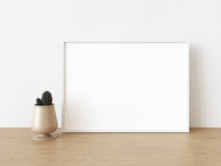 Empty white rectangular horizontal frame stands on light wood table against wall. Mockup of poster frame close up in home interior with cactus, 3D illustration