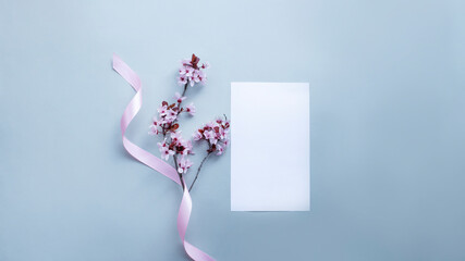 Cherry blossom with pink ribbon and blank space for text on light grey background. 