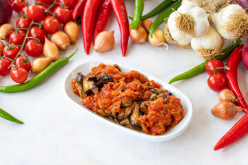 Grilled eggplant salad appetizer with tomato sauce (with eggplant sauce or saksuka). Traditional Middle Eastern meze beside the main course. Layout on white wood