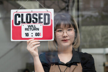 Woman Close Her Shop by  Hanging Close Sign on Glass Door