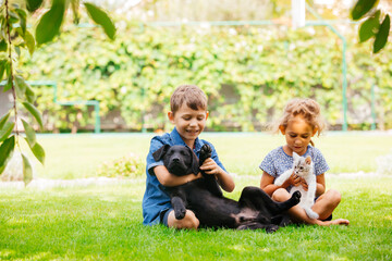Fototapeta na wymiar Close relationship between siblings and their pets