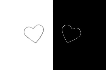 Two metal hearts isolated on black and white backgrounds