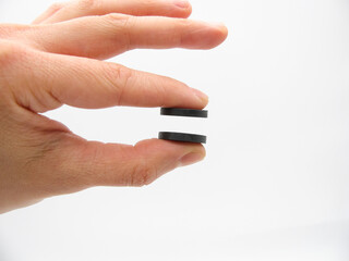 the two round little gray magnets between the two fingers of the hand do not touch each other