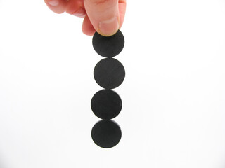 four round little gray magnets hang by a chain in his hand