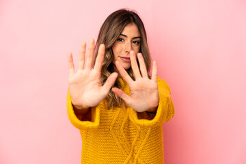 Young caucasian woman isolated standing with outstretched hand showing stop sign, preventing you.