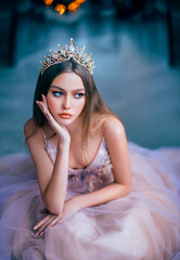 fantasy beauty girl princess in golden crown. Medieval vintage purple dress. Capricious attractive face. Historical woman lady glamorous queen. Fashion model posing emotional portrait. Blue background © kharchenkoirina