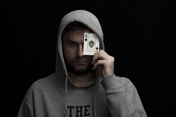 Man in hoodie with playing cards in his hand 