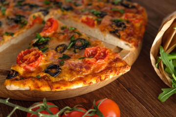 Pizza with cheese, olives, tomatoes and herbs.