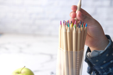 Close up of a child hand picking colored pencil with copy space 