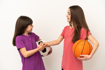 Little sisters playing football and basketball isolated on white background handshaking after good deal