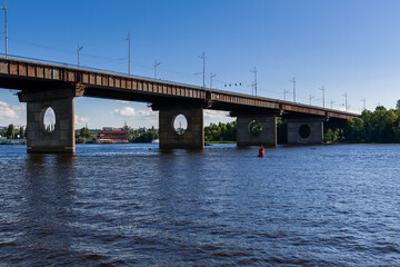 Bridge on a river against a blue sky and clouds