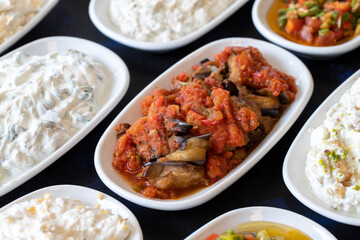 Traditional Turkish and Greek food appetizer table. Grilled eggplant salad (saksuka), Anamur salad, Baba Ghanoush (Mutabbal), pasha appetizer, spicy paste or harissa, purslane salad. Selective focus