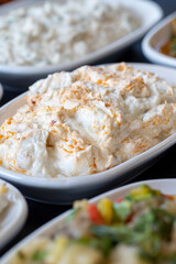 Traditional Turkish and Greek food appetizer table. Grilled eggplant salad (saksuka), Anamur salad, Baba Ghanoush (Mutabbal), pasha appetizer, spicy paste or harissa, purslane salad. Selective focus