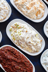 Traditional Turkish and Greek food appetizer table. Grilled eggplant salad (saksuka), Anamur salad, Baba Ghanoush (Mutabbal), pasha appetizer, spicy paste or harissa, purslane salad. Top view