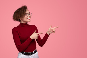 Cheerful young woman pointing aside