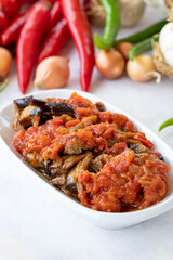 Grilled eggplant salad appetizer with tomato sauce (with eggplant sauce or saksuka). Traditional Middle Eastern meze beside the main course. Layout on white wood