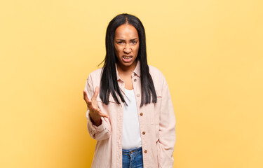young black woman looking angry, annoyed and frustrated screaming wtf or what’s wrong with you