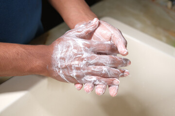 Fototapeta premium young man washing hands with soap warm water 