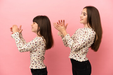 Little sisters girls isolated on pink background applauding after presentation in a conference