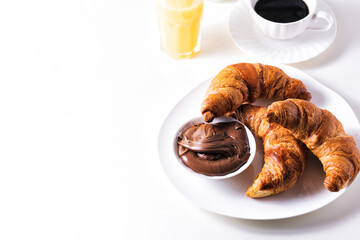 Croissant with chocolate hazelnut spread and cup of coffee on a white table. Continental breakfast with fresh orange juice