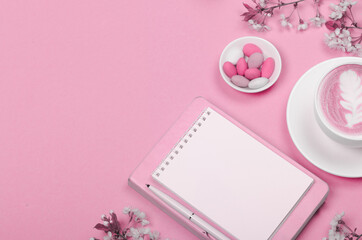 Creative flat lay of workspace desk, notepad and lifestyle objects on pink background