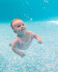 Baby background. Happy infant learn to swim, dive underwater with fun in pool to keep fit. Diving.