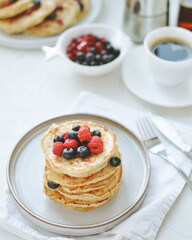 stack of pancakes with berries on a plate