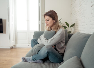 Young sad woman suffering from depression feeling desperate and lonely at home