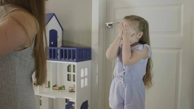 Mom gives a kitten to her daughter. Happy little girl jumping and laughing. Little girl receives a kitten as a gift . Beautiful little girl wint long blond hair.