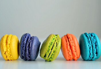 Multicolored macaroons on white background, close up
