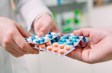 Close up of a girl hands buying pills in a pharmacy.