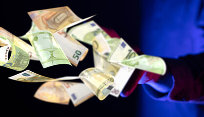 dark euro banknote in hand rain