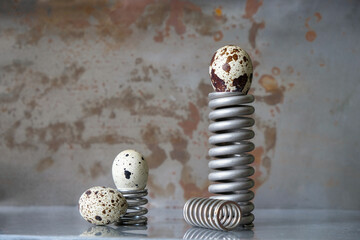 Modern still life with quail eggs and metal springs. Copy space. 