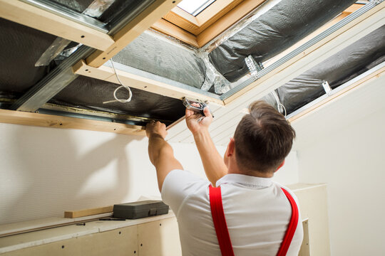 the contractor is installing a wood panels under the roof
