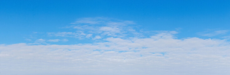White dense clouds on a blue sky, panorama