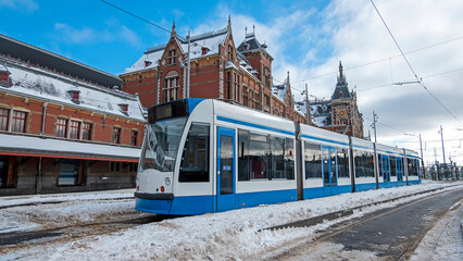 Fototapeta na wymiar Tram waiting in winter in front of the Central Station in Amsterdam the Netherlands